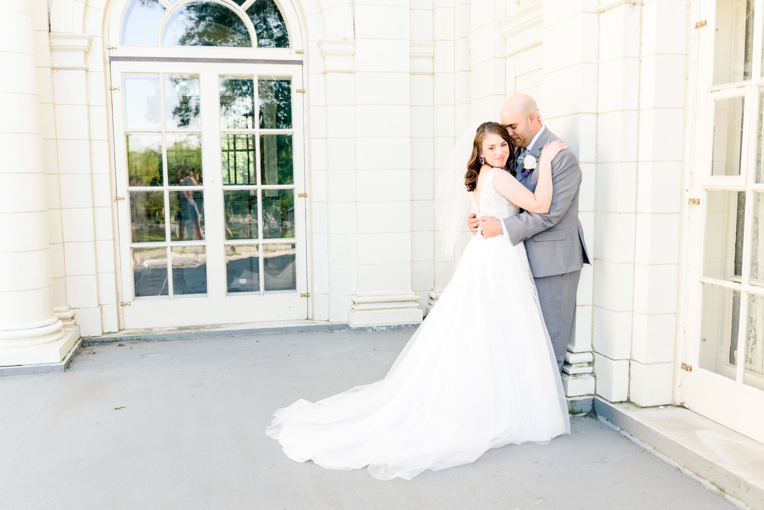Bride and Groom embracing in front of a marble building in Willoughby Ohio